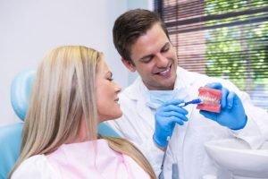 dentist explaining dental implant treatment options to a patient during consultation